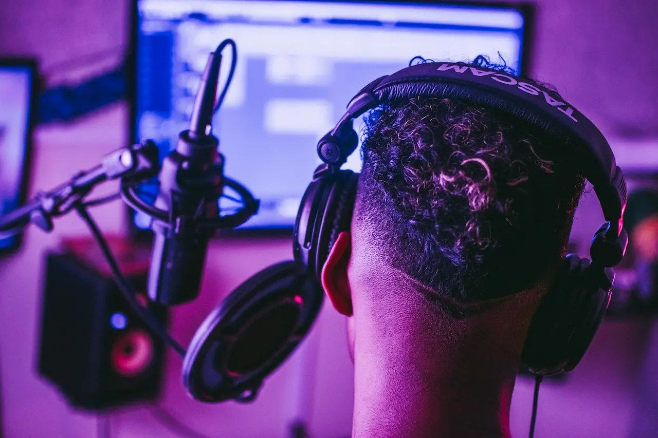 A man with headphones on in front of a computer.