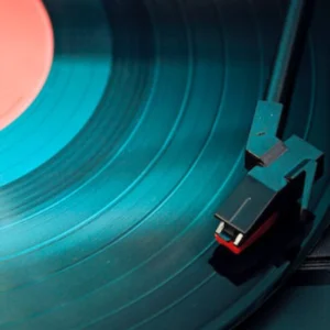 A record player with the lid open on a blue record.