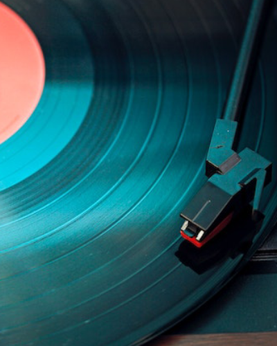 A record player with the lid open on a blue record.